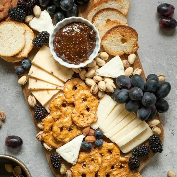 Tabla de quesos con uvas, nueces y galletas